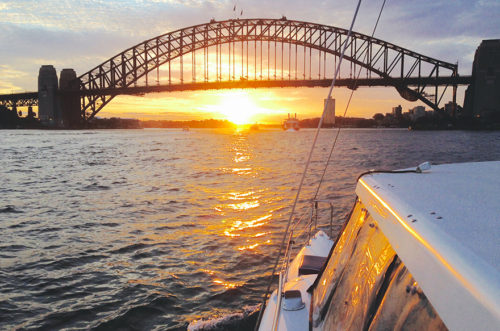 Cruising the harbour and watching the sun setting underneath the Sydney Harbour Bridge. Image - Sea Sydney Harbour.